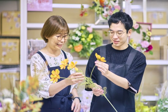 花を選定する従業員とサポートスタッフ